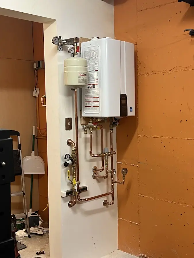 Plumbing technician inspecting water heater connections in Kings Point